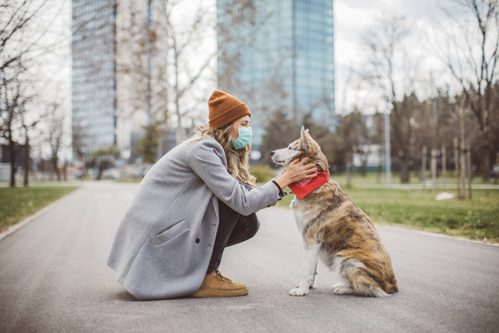Newer alone when you have dog Woman during pandemic isolation walking with her dog in park