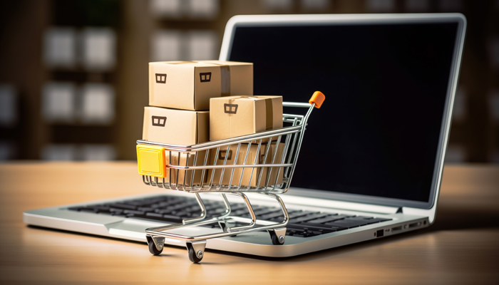 Online shopping concept with miniature shopping cart standing in Der Onlinehandel leidet unter schwacher Kaufbereitschaft.
