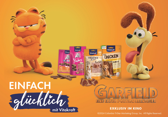 cute red-haired puppy of the corgi dog lies on a natural green m Vitakraft führt eine Couponing-Aktion durch.